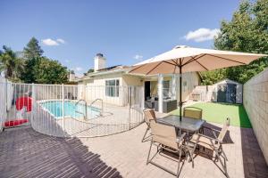 a patio with a table with an umbrella and a pool at Pet-Friendly Family House with Pool and Backyard in Bakersfield