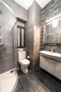 a bathroom with a toilet and a sink and a shower at 49 Sunrise Lodge in Għajnsielem