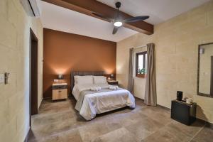 Schlafzimmer mit einem Bett und einem Deckenventilator in der Unterkunft 49 Sunrise Lodge in Għajnsielem