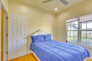 een slaapkamer met een blauw bed en een raam bij Greensboro Townhome with Deck about half Mi to Downtown! in Greensboro