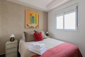 um quarto com uma cama com toalhas em Sunshine Studio - GRU em Guarulhos