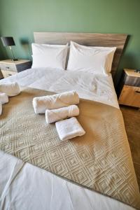 a bed with two towels and two pillows on it at 49 Sunrise Lodge in Għajnsielem