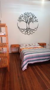 a bedroom with a bed with a tree on the wall at Posada the secret in Colonia del Sacramento