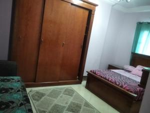 um quarto com um armário de madeira e uma cama em سيدي بشر السرايا em Alexandria