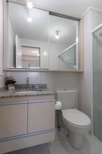 a bathroom with a toilet and a sink and a mirror at Sunshine Studio - GRU in Guarulhos