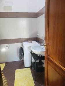 een badkamer met een wastafel, een toilet en een deur bij Romantica casa vacanza direttamente in piscina in Castiglione del Lago