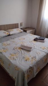 Una cama con una manta blanca con flores. en Romantica casa vacanza direttamente in piscina, en Castiglione del Lago