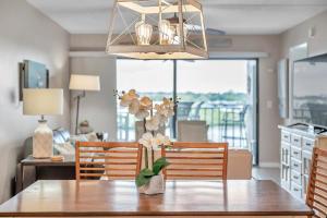 - une table à manger avec un vase de fleurs dans l'établissement Pet-friendly 2-bed Condo With Amazing Waterfront Views, à Clearwater Beach