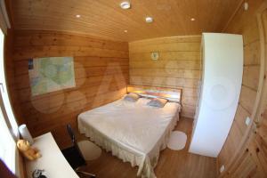 a small room with a bed in a wooden cabin at Modern cottage by the private lake in Lappeenranta