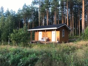 a small cabin in the middle of a forest at Modern cottage by the private lake in Lappeenranta