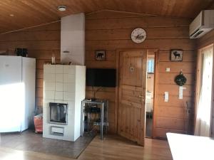 un soggiorno con pareti in legno e TV di Modern cottage by the private lake a Lappeenranta