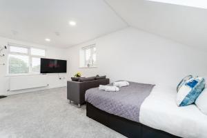 a bedroom with a bed and a flat screen tv at Twickenham Apartments by Charles in Teddington