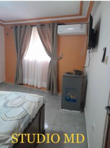 Cette chambre comprend un lit, une fenêtre et une télévision. dans l'établissement Résidence Diakhaby, à Conakry