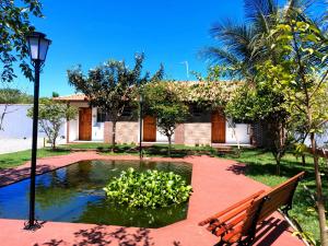 佩魯伊比的住宿－Recanto Bela Vista，房屋前的长凳和池塘