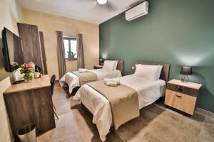a hotel room with two beds and a window at 49 Sunrise Lodge in Għajnsielem