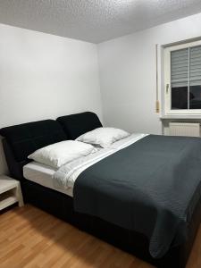 uma cama preta num quarto com uma janela em Cascada Vista em Klettgau