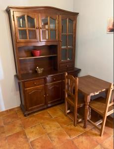 a wooden cabinet with a table and a table and chairs at Hostal La Plata in Oropesa