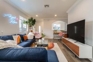 sala de estar con sofá azul y TV de pantalla plana en Angel & Rose * Hollywood DTLA en Los Ángeles