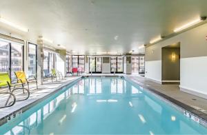 a large swimming pool with yellow chairs in a building at Chelan Resort Suites by DC in Chelan