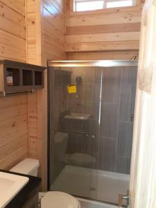 a bathroom with a glass shower with a toilet at 091 Star Gazing Tiny Home near Grand Canyon South Rim Sleeps 8 in Valle