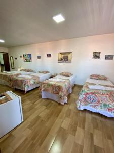 3 camas num quarto com pisos em madeira em Pousada São Pedro em Flecheiras