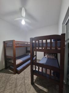 two bunk beds in a room with a ceiling fan at Casa Relaxemar in Caraguatatuba