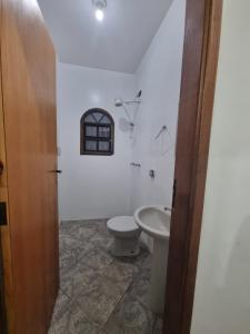 a bathroom with a toilet and a sink at Casa Relaxemar in Caraguatatuba