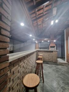 a kitchen with two stools and a brick counter at Casa Relaxemar in Caraguatatuba