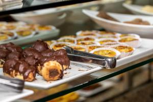 a tray of donuts and other pastries in a bakery at Fluminense Hotel in Rio de Janeiro