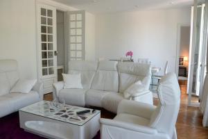 a white living room with a white couch and chairs at Eiffel Tower Oasis 30m from Eiffel Tower in Paris