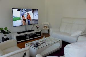 a living room with a white couch and a flat screen tv at Eiffel Tower Oasis 30m from Eiffel Tower in Paris