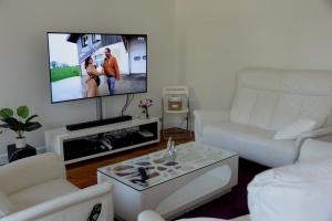 a living room with a white couch and a flat screen tv at Eiffel Tower Oasis in Paris