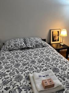 a bed with a black and white blanket and a box on it at Eiffel Tower Oasis 30m from Eiffel Tower in Paris