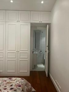 a bedroom with white cabinets and a bathroom with a shower at Eiffel Tower Oasis 30m from Eiffel Tower in Paris