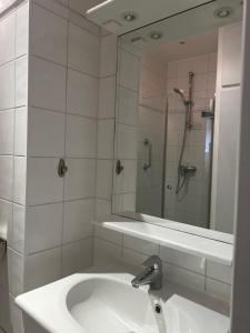 a bathroom with a sink and a shower with a mirror at Eiffel Tower Oasis 30m from Eiffel Tower in Paris