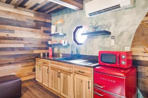 La cuisine est équipée d'un réfrigérateur rouge et d'un four micro-ondes rouge. dans l'établissement Nature Mystique Retreat, 