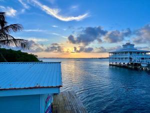 a building on a dock on the water at sunset at Dockside Utila Ocean front suites in Utila