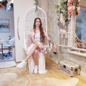 a woman in a white dress sitting on a chair at Live House Boutique Hotels in Sao Paulo