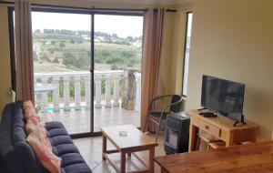 a living room with a couch and a television and a balcony at Strandvagen Maitencillo in Maitencillo