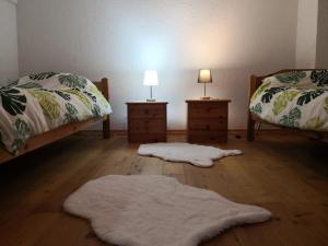 Zimmer mit 2 Betten und 2 Nachttischen mit Teppichen in der Unterkunft Haus am Fluss in Urft