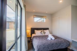 a bedroom with a bed and a window at Skyblue Tekapo in Lake Tekapo