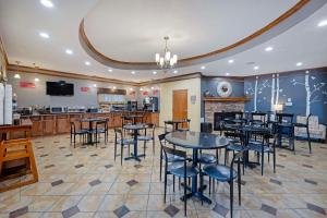 restauracja ze stołami i krzesłami oraz bar w obiekcie Best Western Plus Guymon Hotel & Suites w mieście Guymon