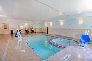ein großer Pool mit blauen Stühlen in einem Gebäude in der Unterkunft Best Western Plus Guymon Hotel & Suites in Guymon