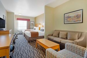 a hotel room with a bed and a couch at Best Western Plus Guymon Hotel & Suites in Guymon