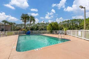 een zwembad in een tuin met een hek bij Quality Inn Conference Center at Citrus Hills in Hernando