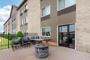 a patio with chairs and tables in front of a building at Comfort Inn Bangor in Bangor