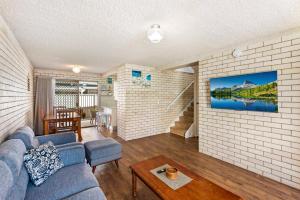 a living room with a blue couch and a brick wall at Kenway Lodge in Ballina
