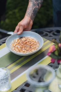 a person holding a bowl of food on a table at Cedrela Eco-Lodge & Restaurante in El Copey