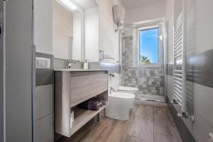 bagno con lavandino, servizi igienici e finestra di La casa di campagna a Manciano