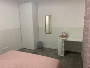 una camera con letto, scrivania e specchio di Welcome Milano Guest House a Milano